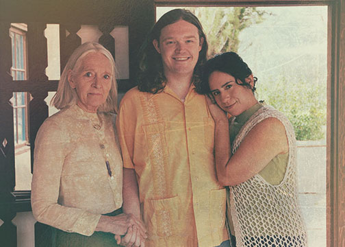 Robert G. standing with two family members on a porch