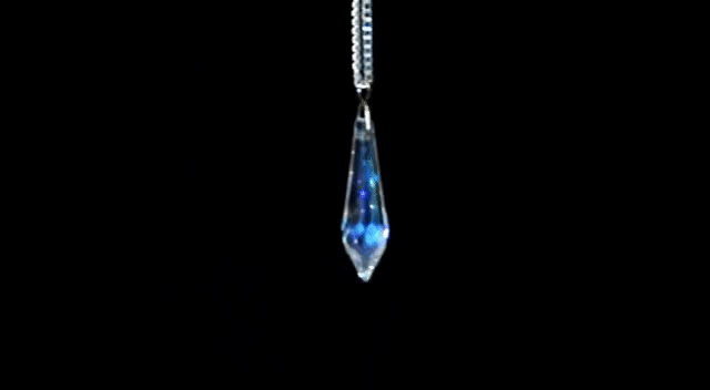 A crystal pendulum swinging, while your reading is composed