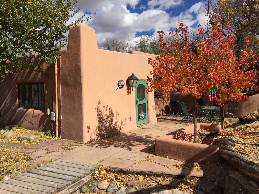 Adobe exterior with a hand-painted parrot on the door, in autumn color
